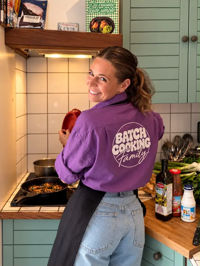 Mathilde aux fourneaux, de dos, dans une veste au logo Batch Cooking Family